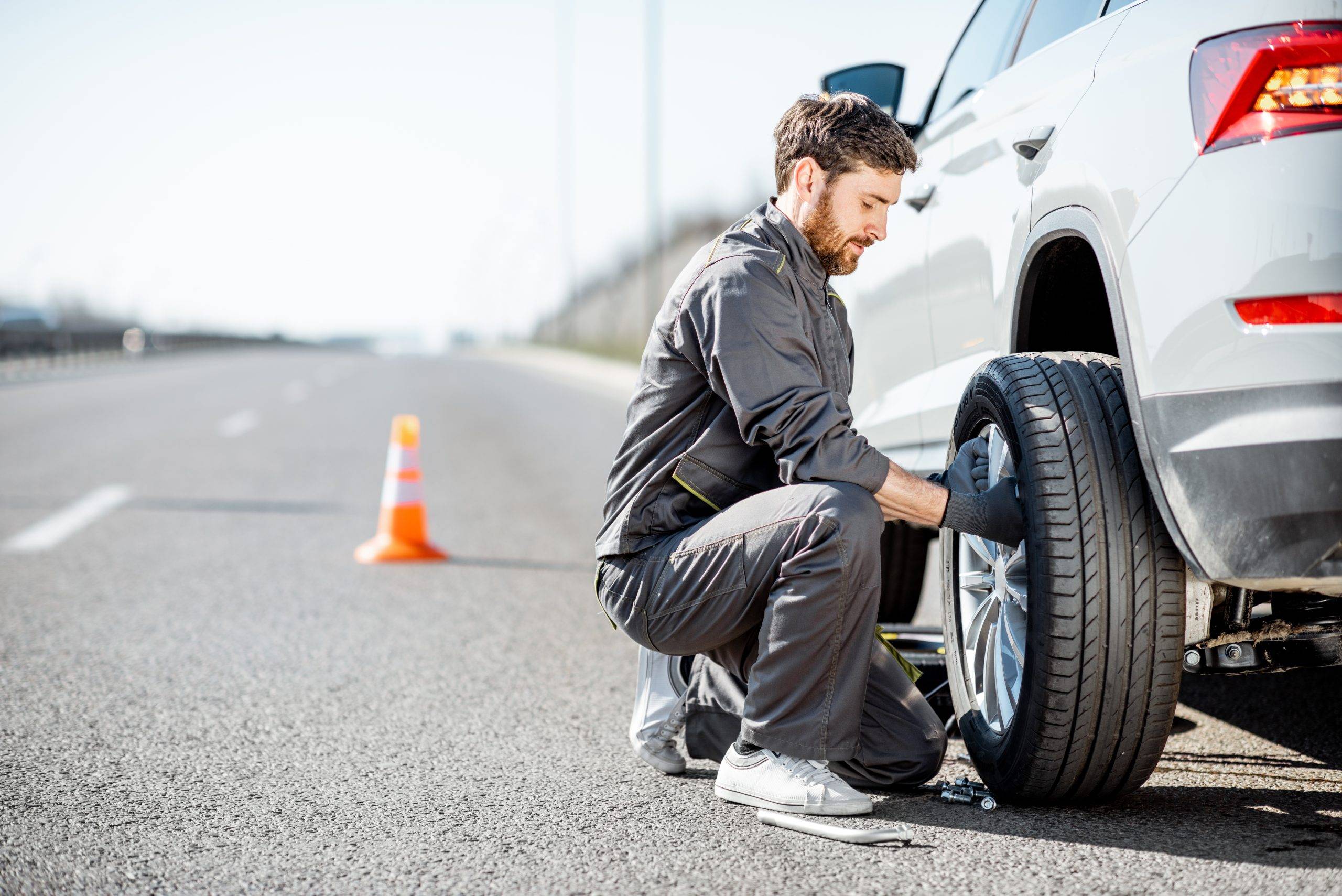 Worker Changing Car Wheel On The Highway